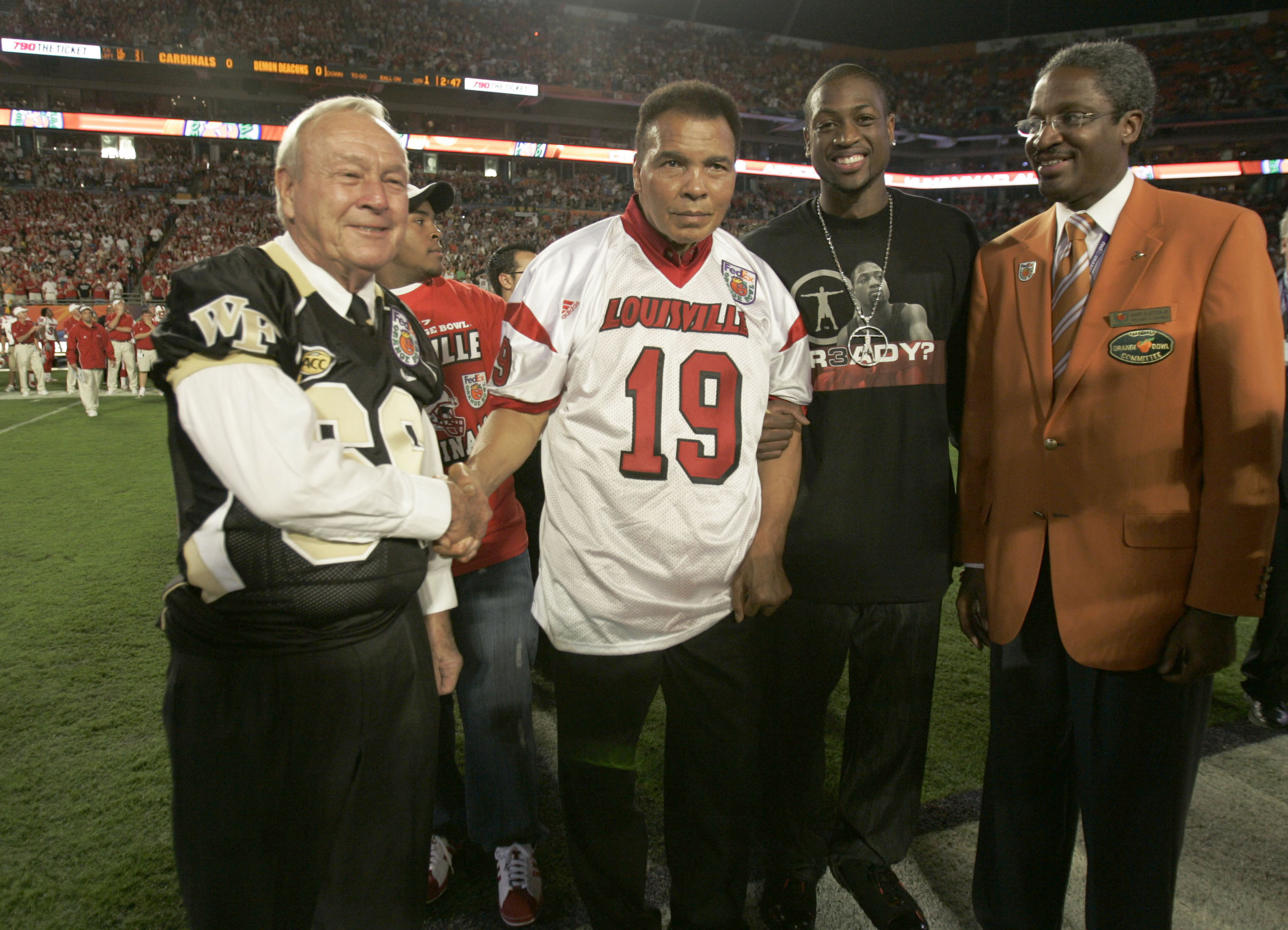 Golf great Arnold Palmer greets boxing legend Muhammad Ali and Miami Heat player Dwyane Wade prior to the coin toss at the Orange Bowl in Miami in 2006. (Lynne Sladky/Associated Press)