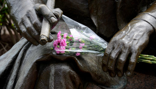 Flowers lie at the Art Rooney statue outside Heinz Field. (Lake Fong/Post-Gazette)