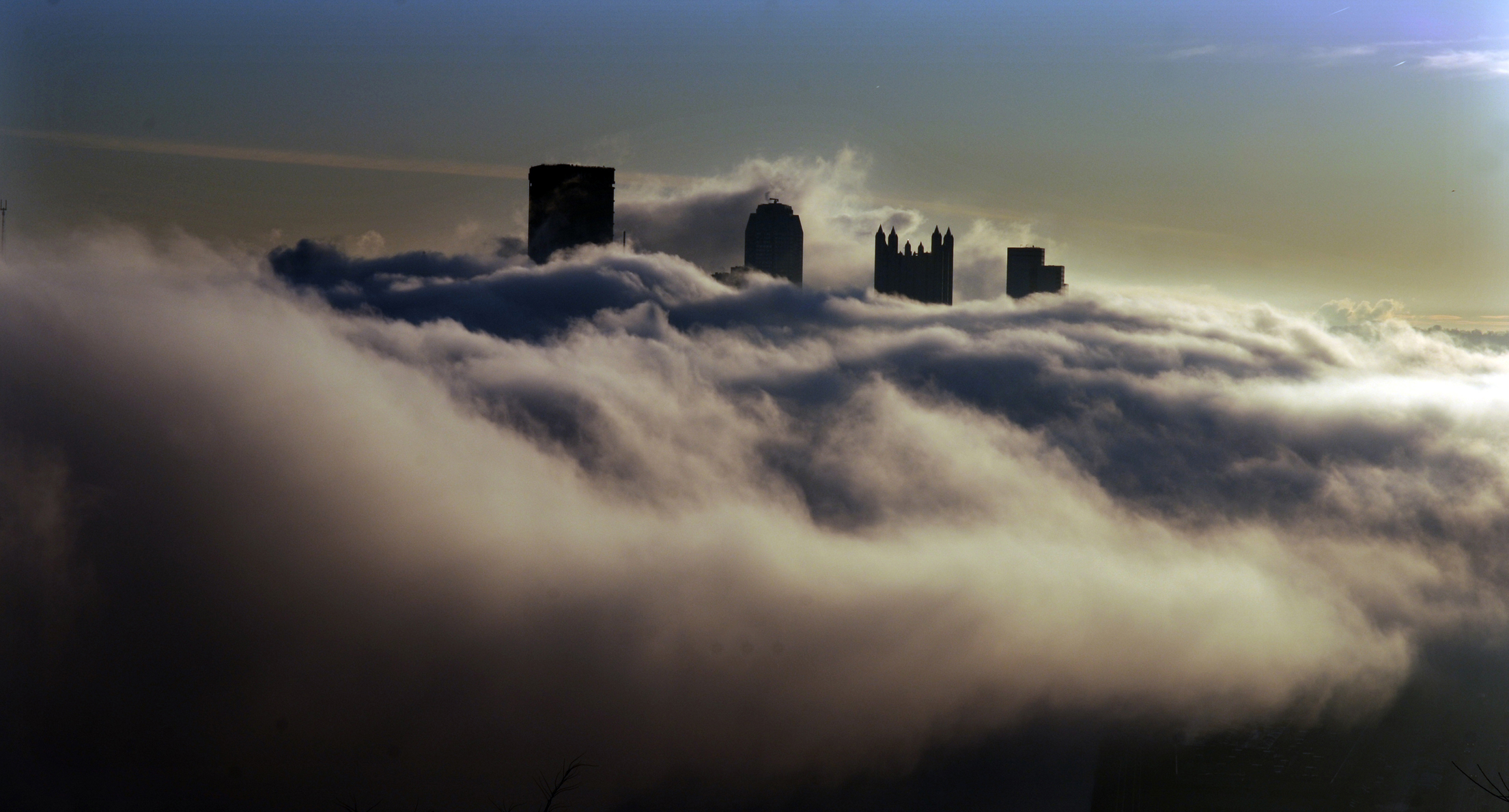 A sea of heavy fog surrounds the Downtown Pittsburgh skyline in this view from the West End Overlook. (Darrell Sapp/Post-Gazette)