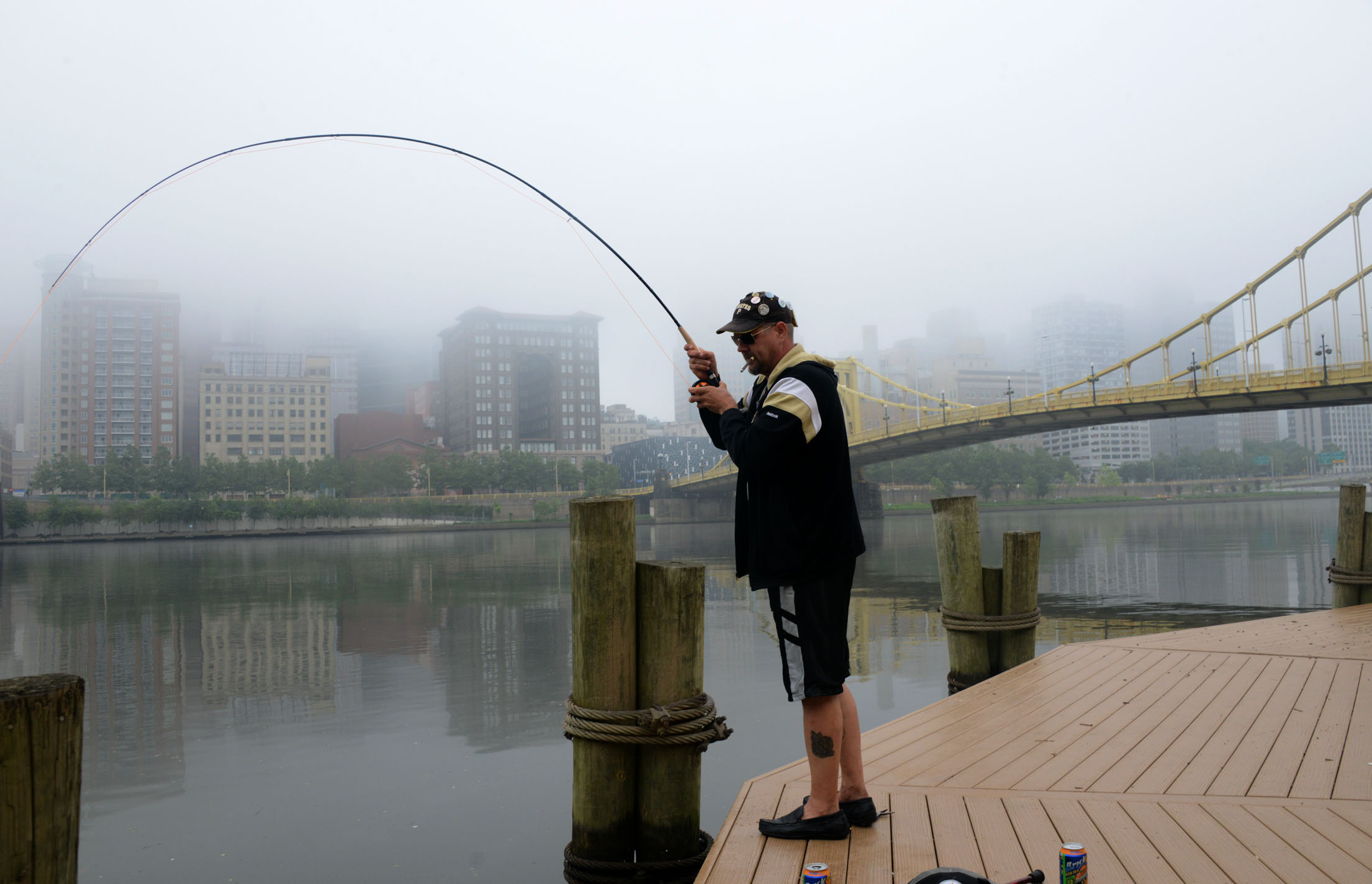 Russ Stratton , of the North Side, gets a "bite" while fishing in the Allegheny River , on the North Shore. (Darrell Sapp / Post-Gazette)