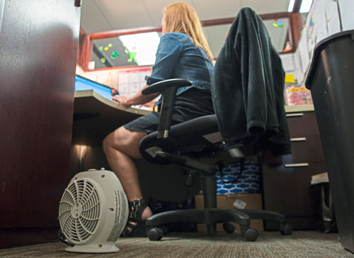 AEC Group Marketing Coordinator Julie Kuna sits at her cubicle, outfitted with a fan and two space heaters. (Rebecca Lessner/Post-Gazette)