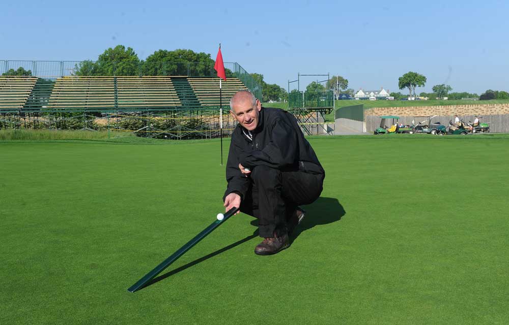 John Zimmers, Oakmont course superintendent, demonstrates green speed using a Stimpmeter, which checks the speed of putting greens. Oakmont's putting surfaces routinely rank as some of the fastest in golf. (Nate Guidry/Pittsburgh Post-Gazette)