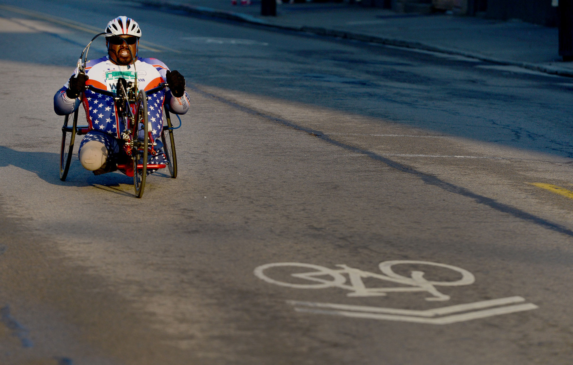 A hand cyclist rides down Carson Street at its intersection with 12th Street.  (Michael Henninger/Post-Gazette) 