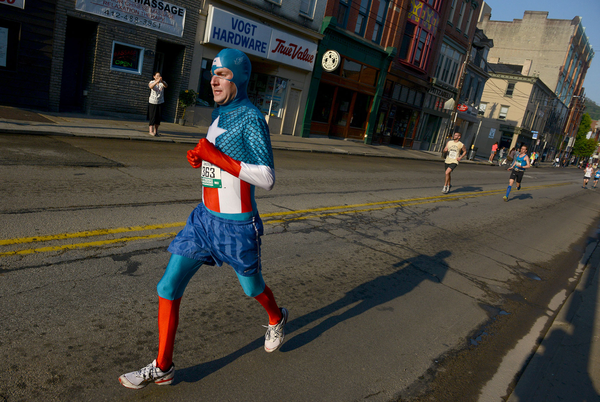 A marathon participant dressed as Captain America runs on Carson Street in the South Side during the 2015 Pittsburgh Marathon, on Sunday, May 3, 2015. (Michael Henninger/Post-Gazette)