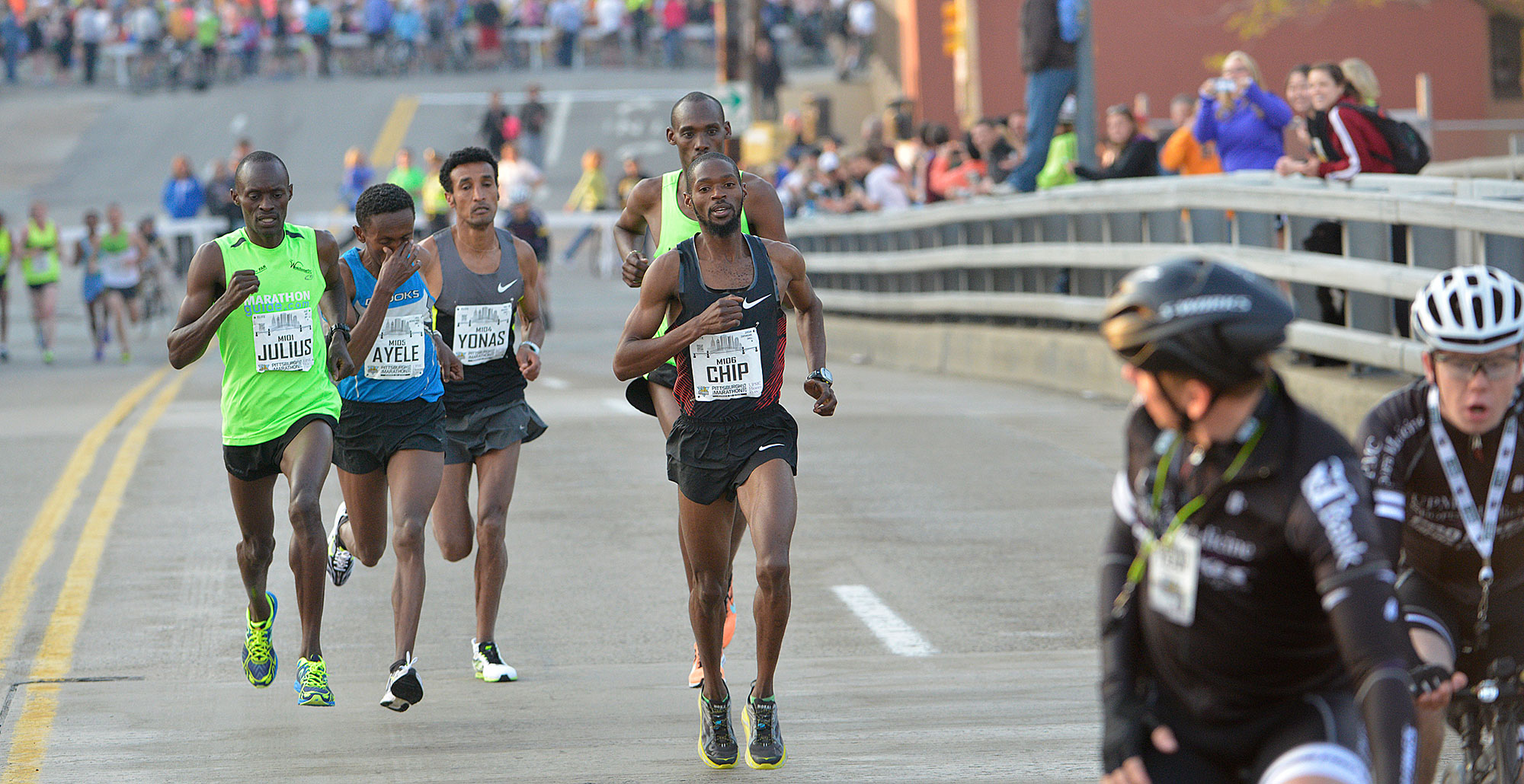 Elite runners leave the Strip District and head over the 16th Street Bridge.  (Larry Roberts/Post-Gazette) 