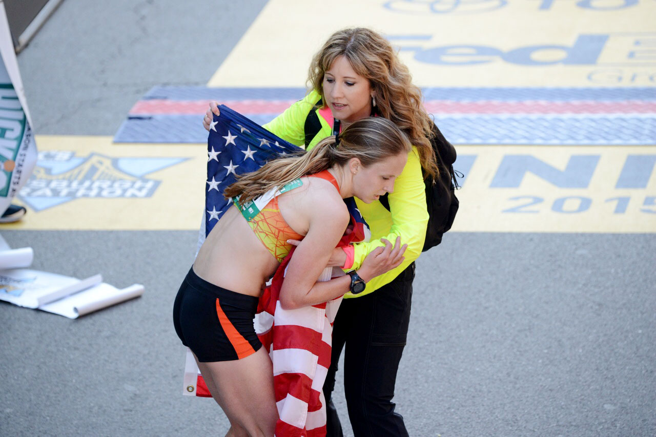 Clara Santucci is covered by the American flag after finishing the Pittsburgh Marathon.  Santucci, who was the first female marathon winner last year, wins again. (Bob Donaldson/Post-Gazette)