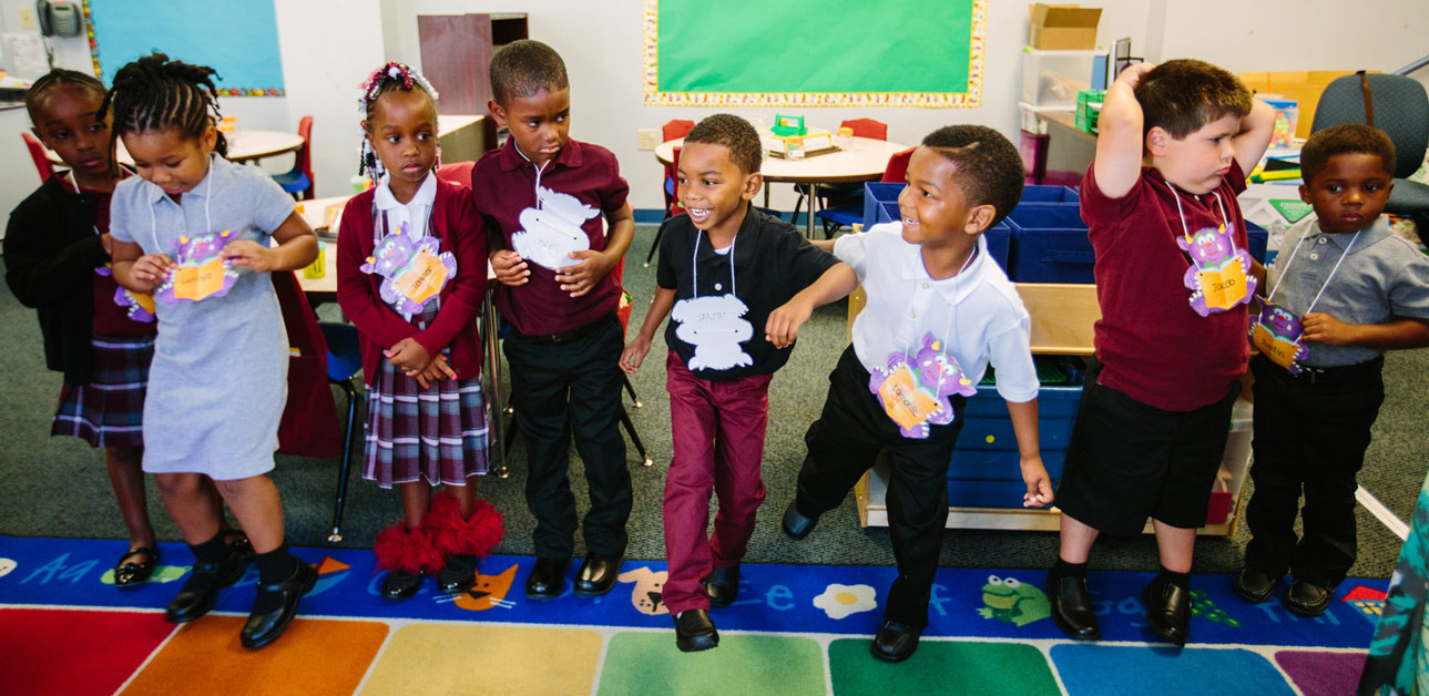 Jay’Lin Herring, fourth from right, and Lamonte Hunter, third from right, dance during story time at Manchester Academic Charter on Aug. 26, 2015. (Andrew Rush/Post-Gazette)