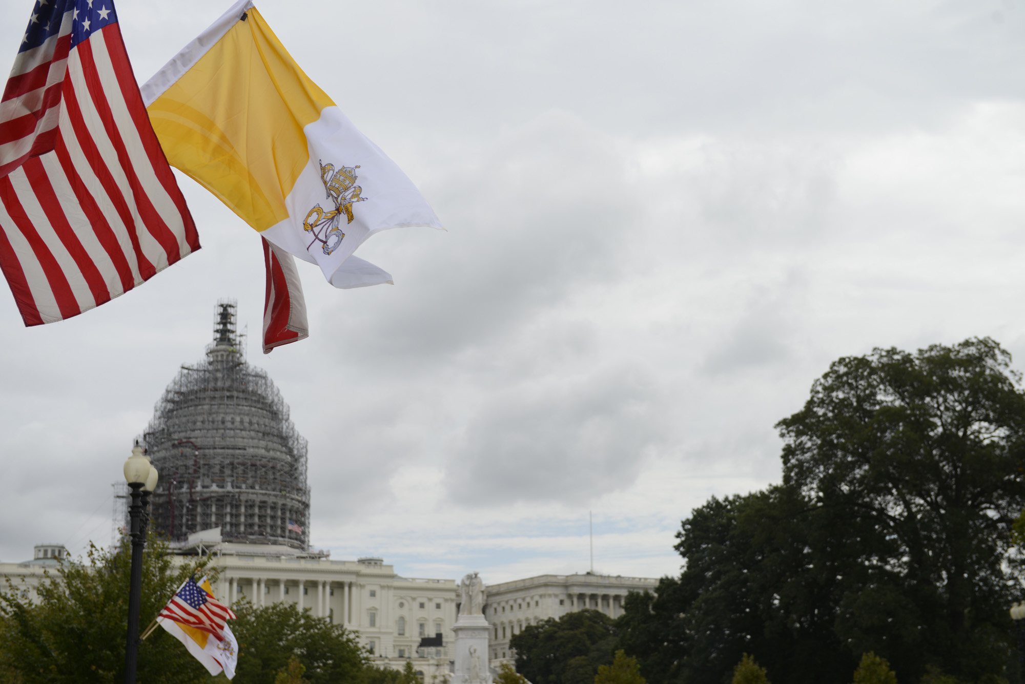 The flag of the Vatican City flies along with the U.S. flag and District of Columbia flag along Constitution Avenue outside the U.S. Capitol in Washington, D.C., Tuesday, Sept. 22, 2015.