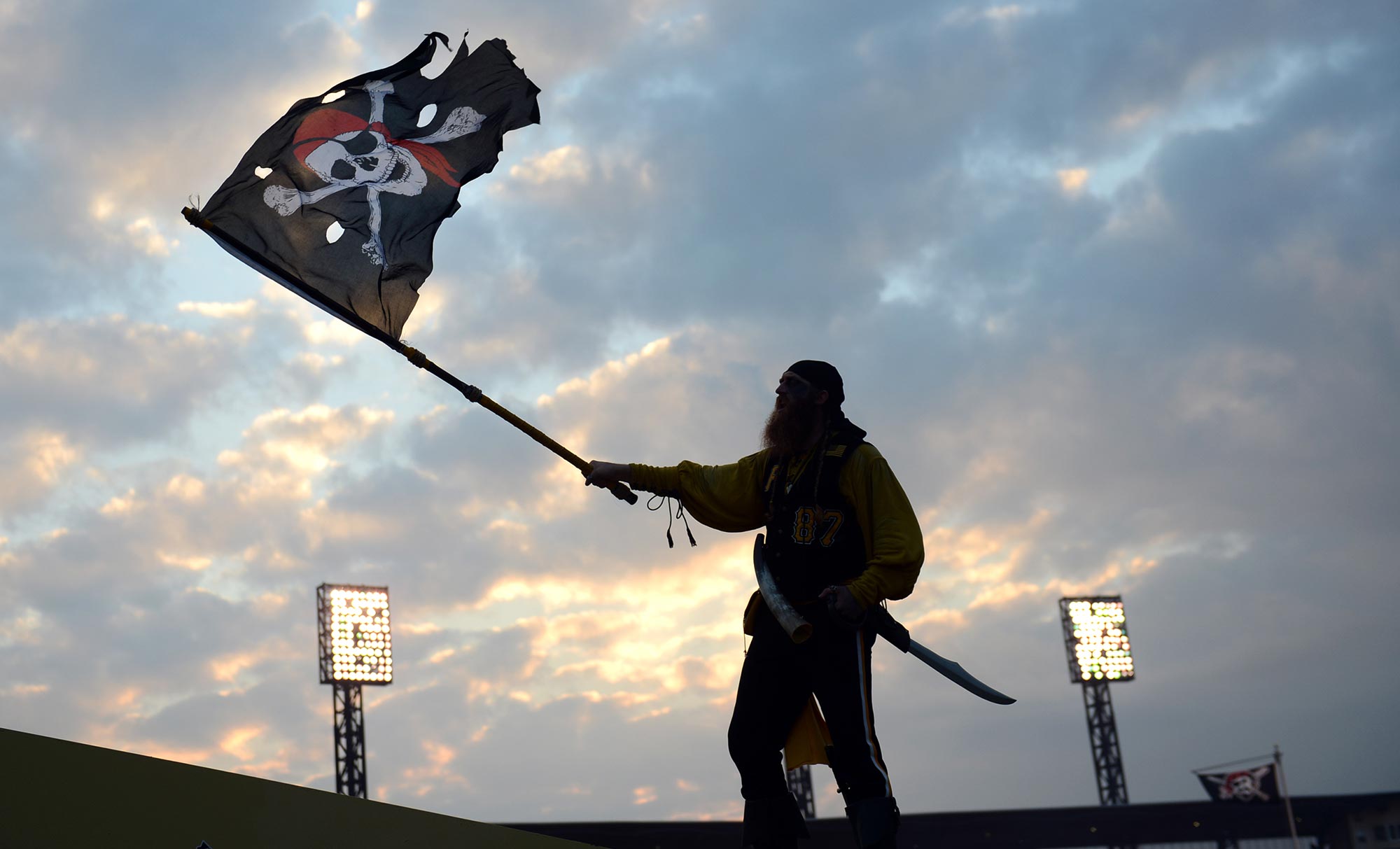 Louis Lambros "Bucco Louie" of Mt. Lebanon cheers for the Pirates from his perch on the Clemente Bridge before the start of the National League wild card on the North Side. (Julia Rendleman/Post-Gazette)